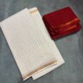 White Onam Saree with contrast blouse featuring copper zari border and zari checks by Aamir Fashion Textile.